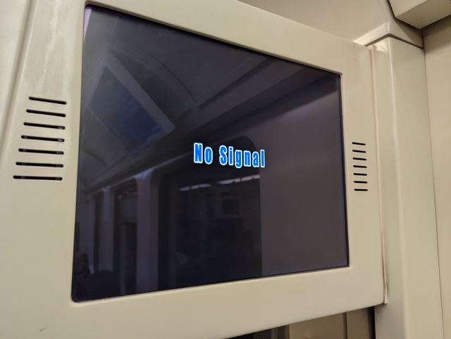 An LCD screen mounted on a white panel displaying the message 